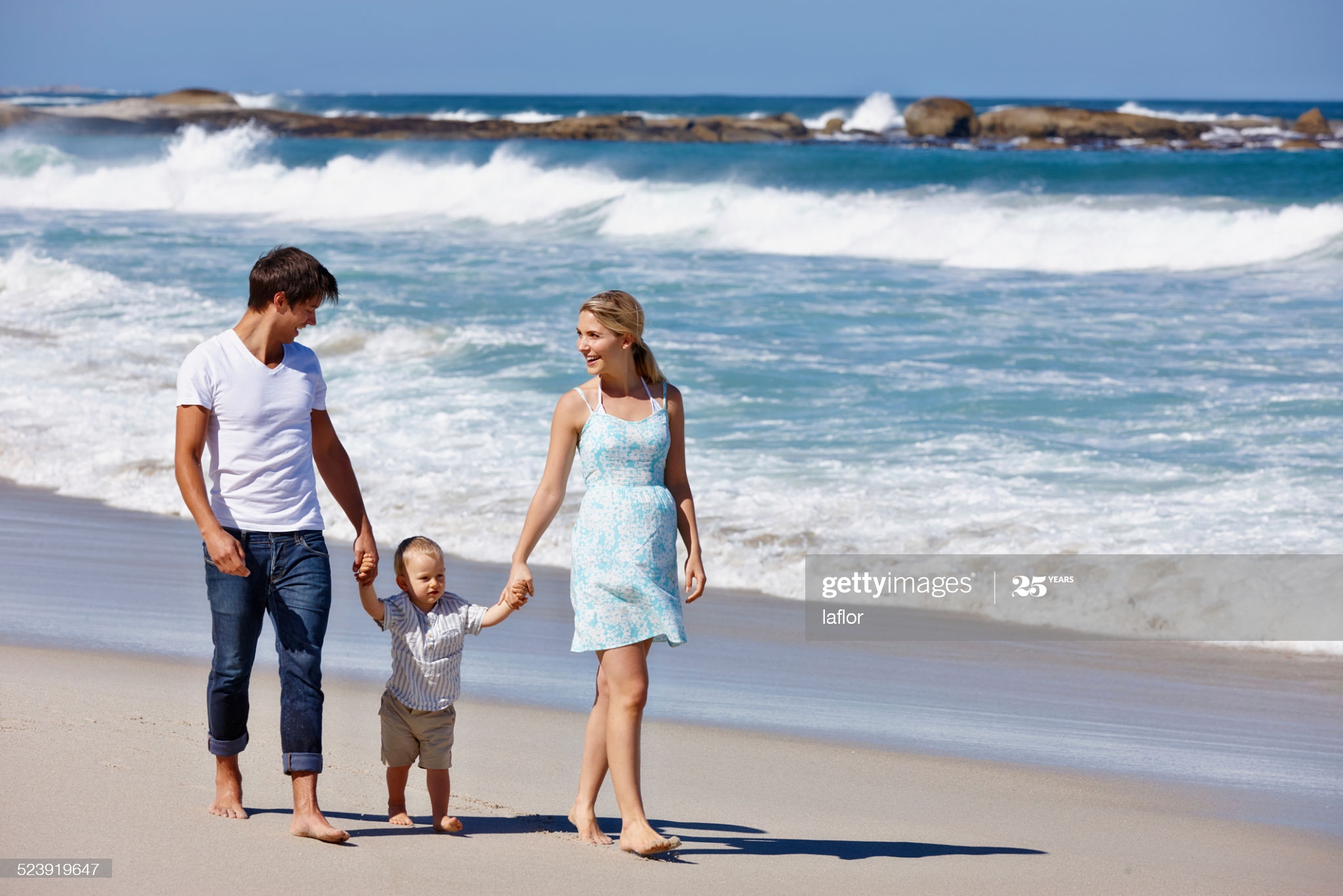 little fella on beach with mom and pops